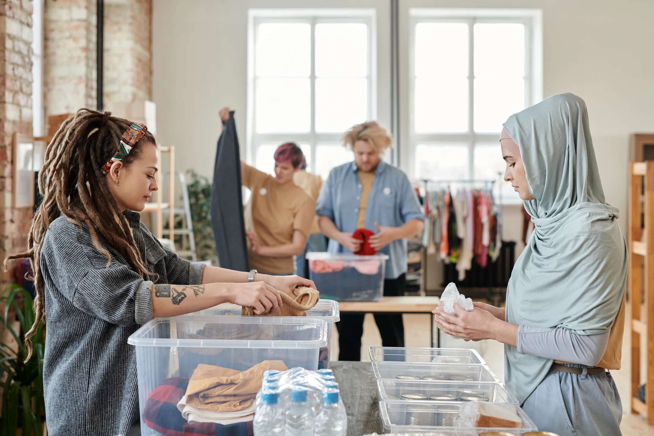 Volunteers sort clothing, food and household donations into containers.